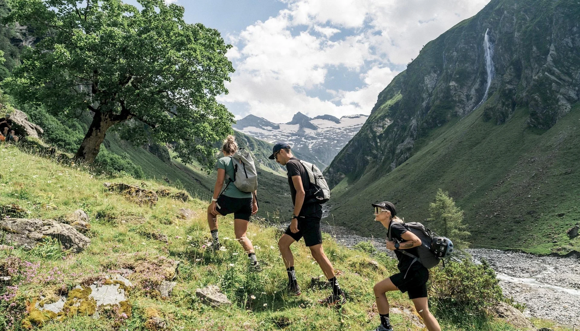 Tourentipps Drei Wanderer steigen in den Bergen an einem sonnigen Tag auf