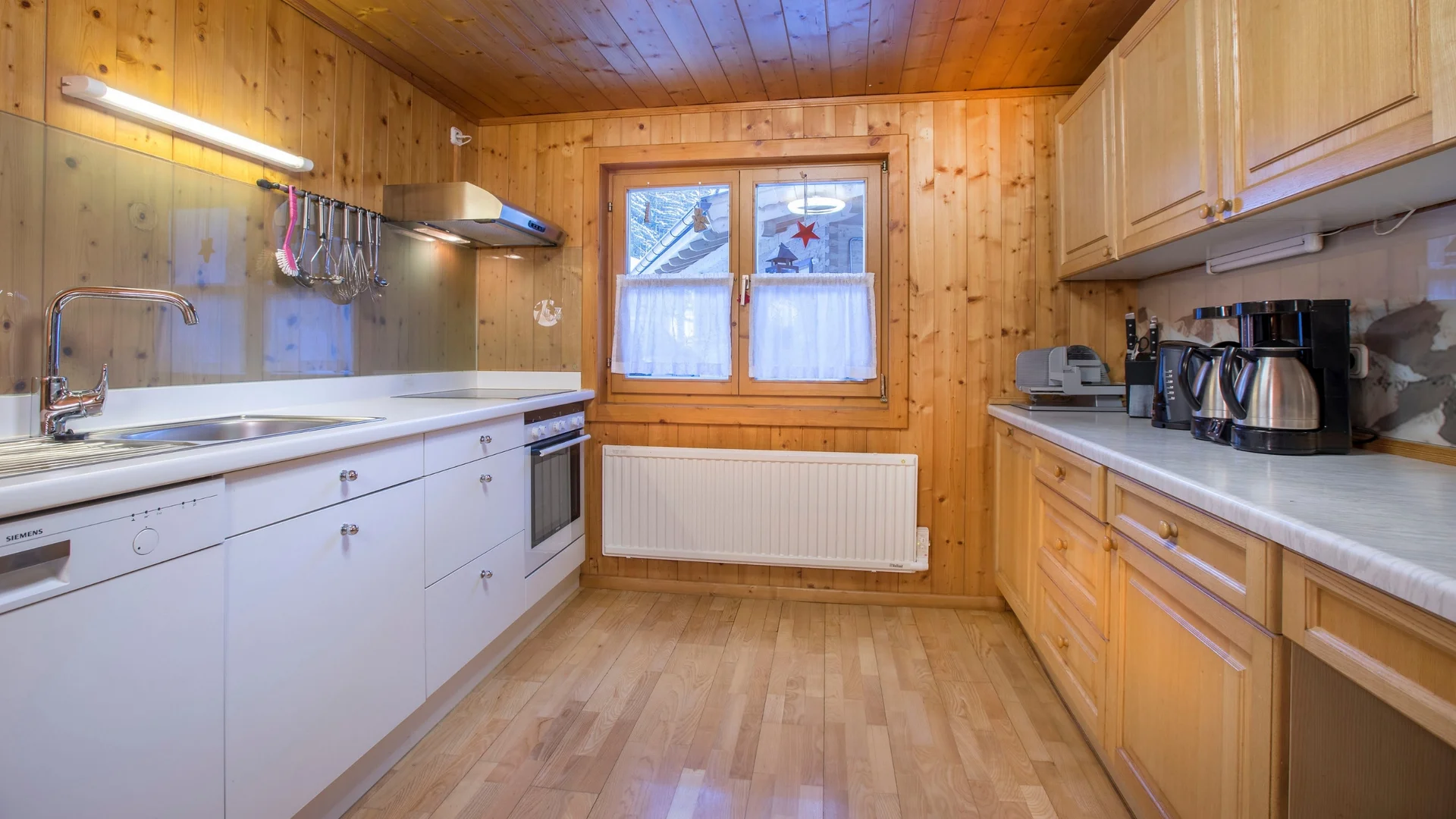 Benefits im Hotel Kleine Küche mit Holzverkleidung, weißen und holzfarbenen Schränken und Fenster