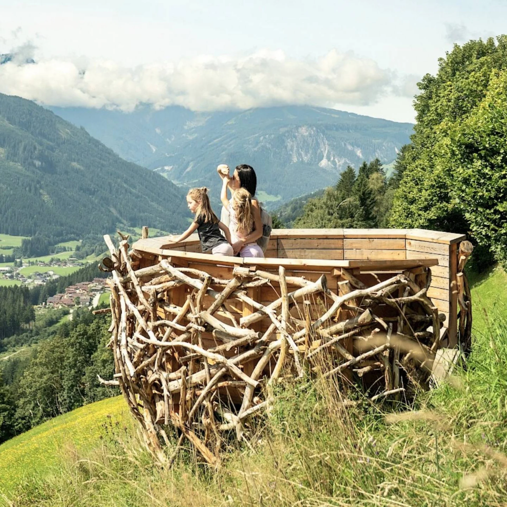 Wandern Familie auf Holzaussichtsplattform des Adler-Toni-Erlebnisweges in der Wildkogel-Arena mit Blick auf die Hohen Tauern