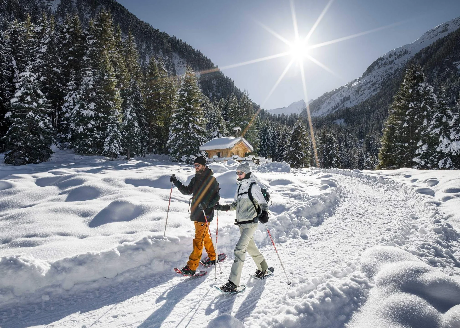 Bergwinter Zwei Personen beim Schneeschuhwandern auf verschneitem Bergweg im Sonnenschein