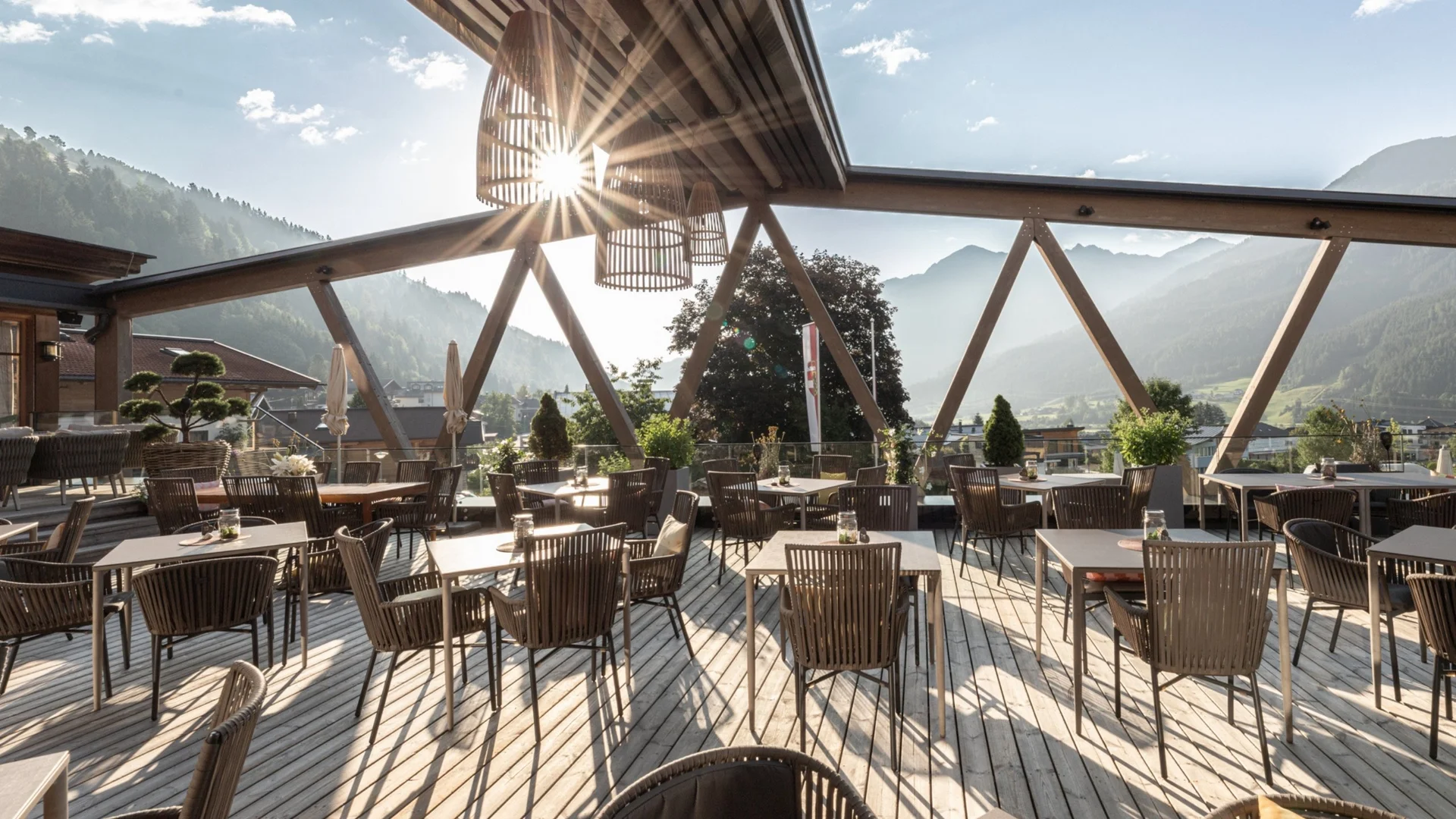Wohnen Sonnige Terrasse mit Tischen und Stühlen und Berglandschaft im Hintergrund