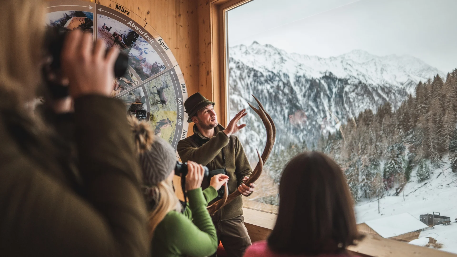 Abseits der Piste Jäger erklärt Hirschgeweih vor verschneiter Berglandschaft mehreren Personen