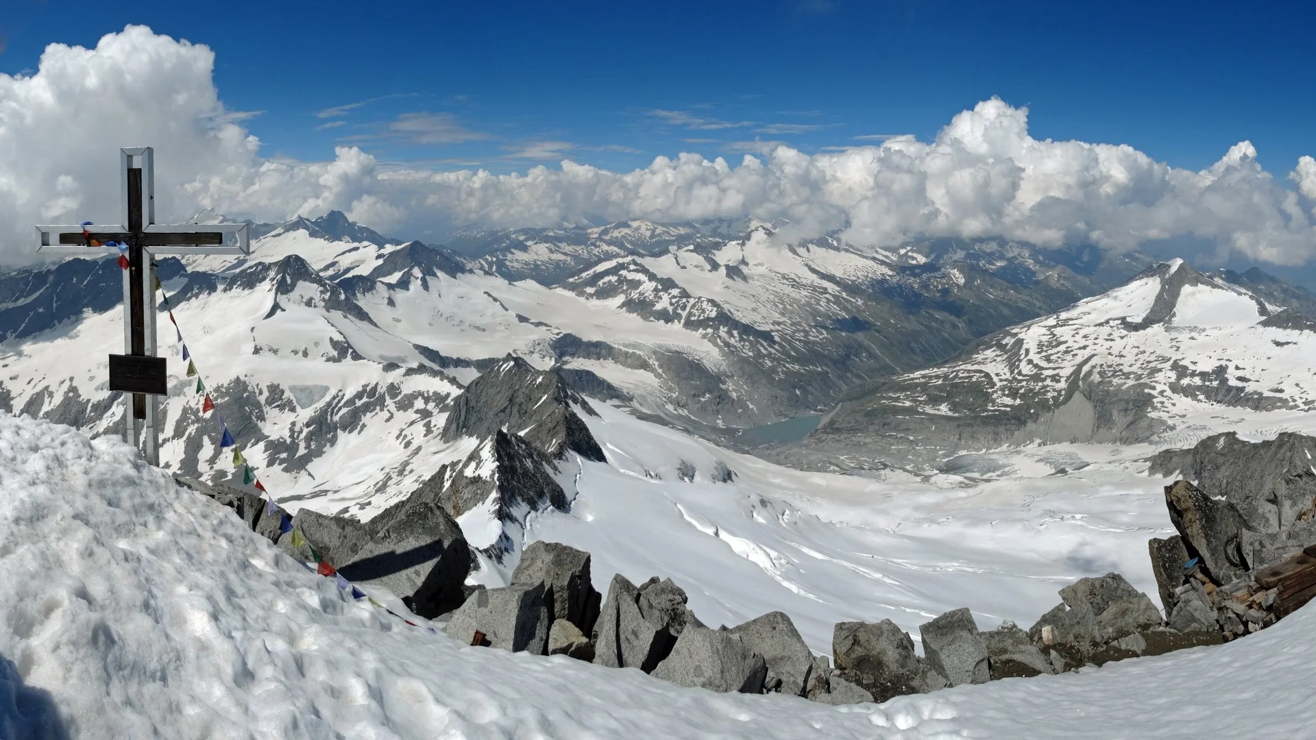 Großvenediger Blick auf schneebedeckte Alpen mit Gipfelkreuz und bunten Gebetsfahnen