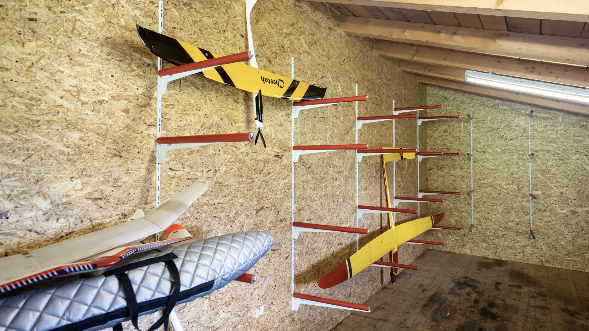 Modell- und Hangfliegen Modellflugzeuge und Zubehör in einem Holzschuppen an der Wand gelagert