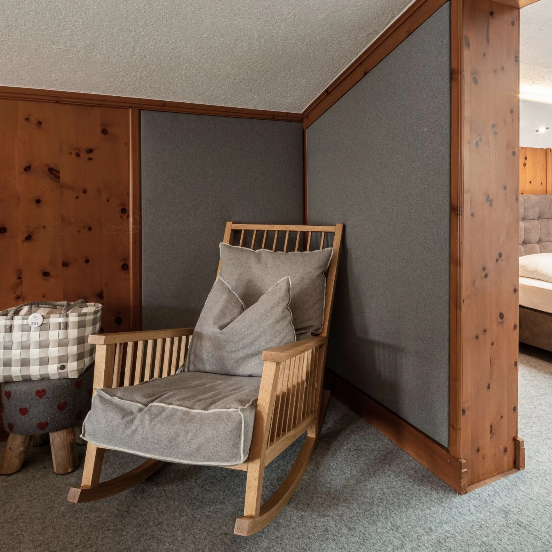 Familienzeit Gemütlicher Schaukelstuhl mit Kissen neben Schlafzimmer mit Spiegelwand