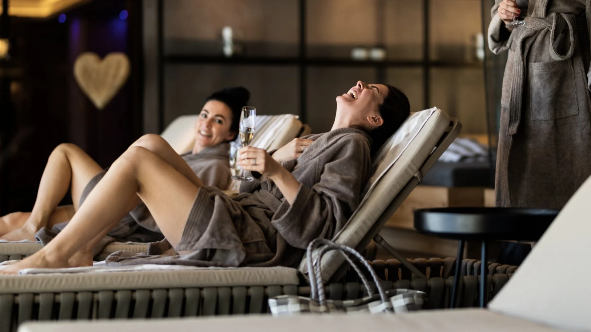 Saunawelt Frauen entspannen in Bademänteln mit Champagner in einer Spa-Lounge