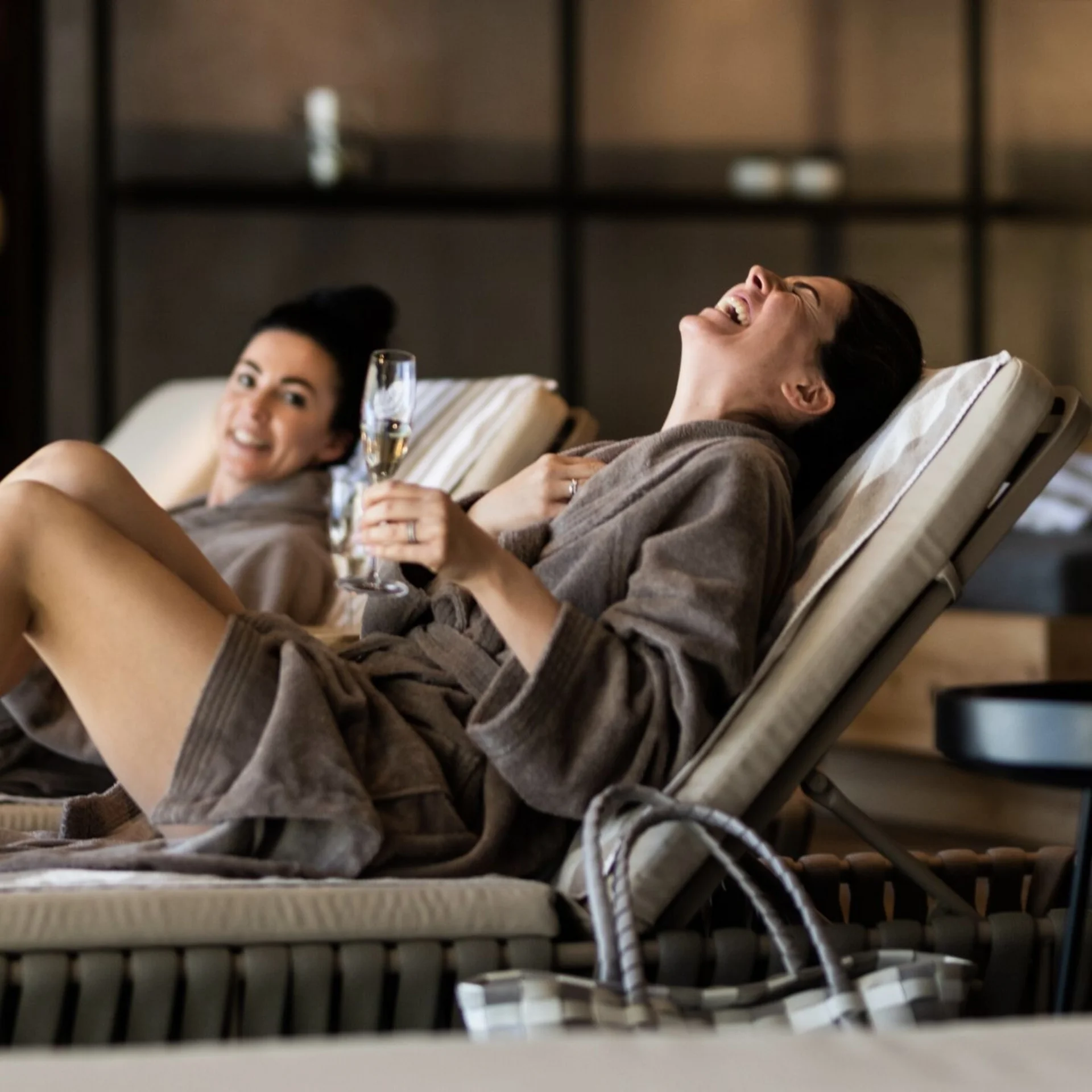 Wellness Frauen entspannen in Bademänteln mit Champagner in einer Spa-Lounge