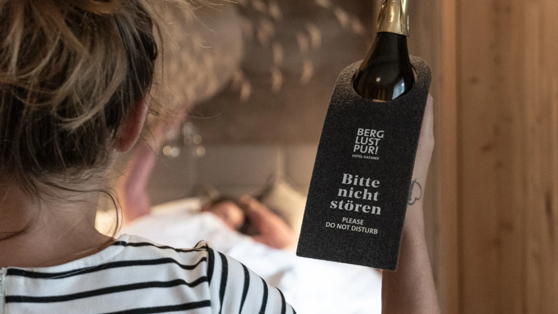 Wohnen Frau hält Bitte nicht stören Schild vor schlafender Person im Hotelzimmer