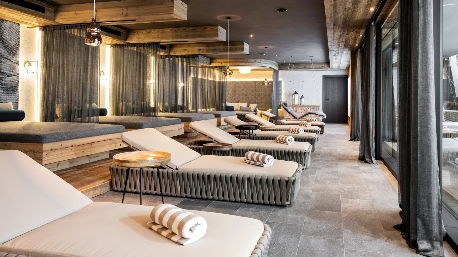 Wellness Entspannungsraum mit Liegestühlen und Holzdecke in moderner Wellnessanlage