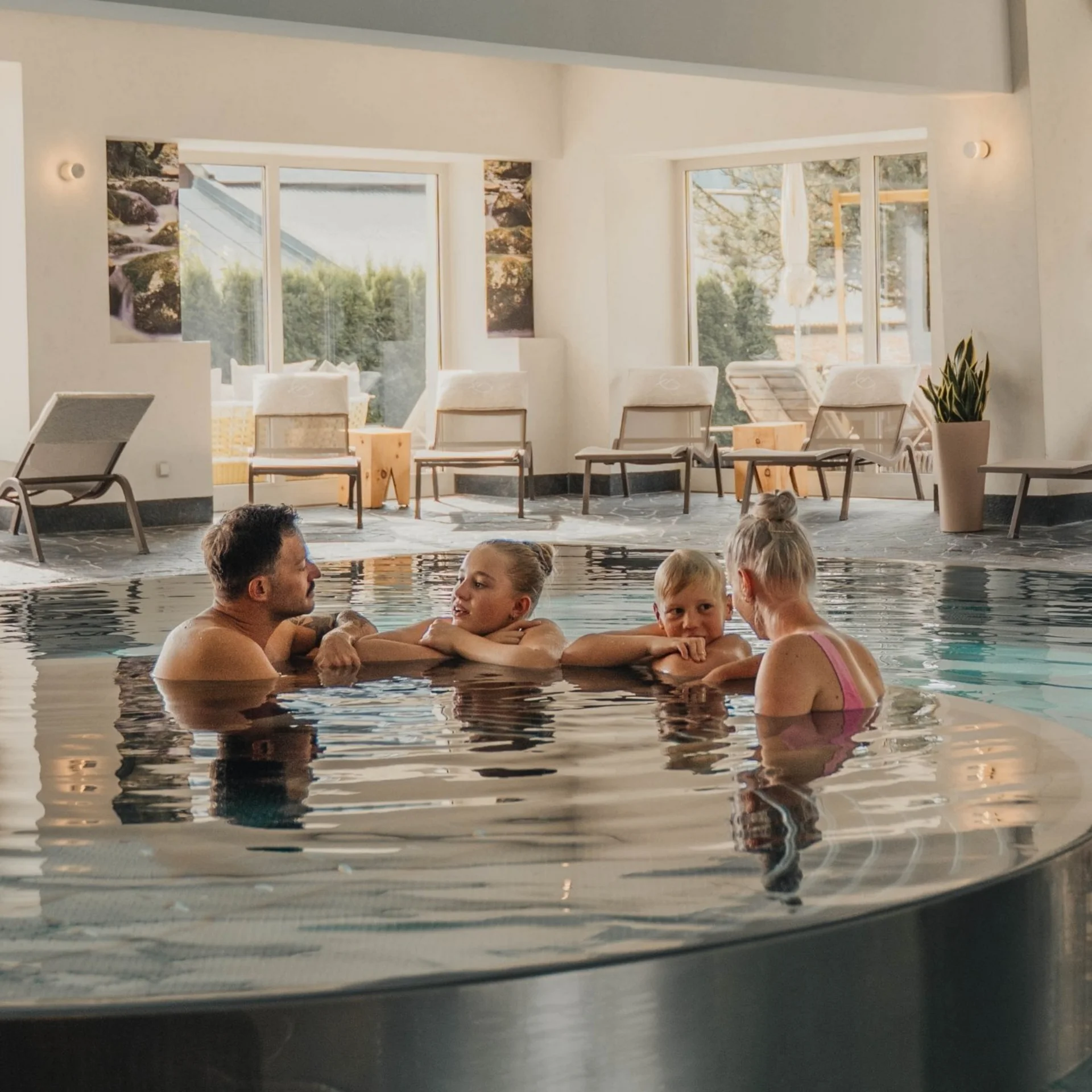 Wellness Familie mit Kindern entspannt im Pool eines Spa-Hotels