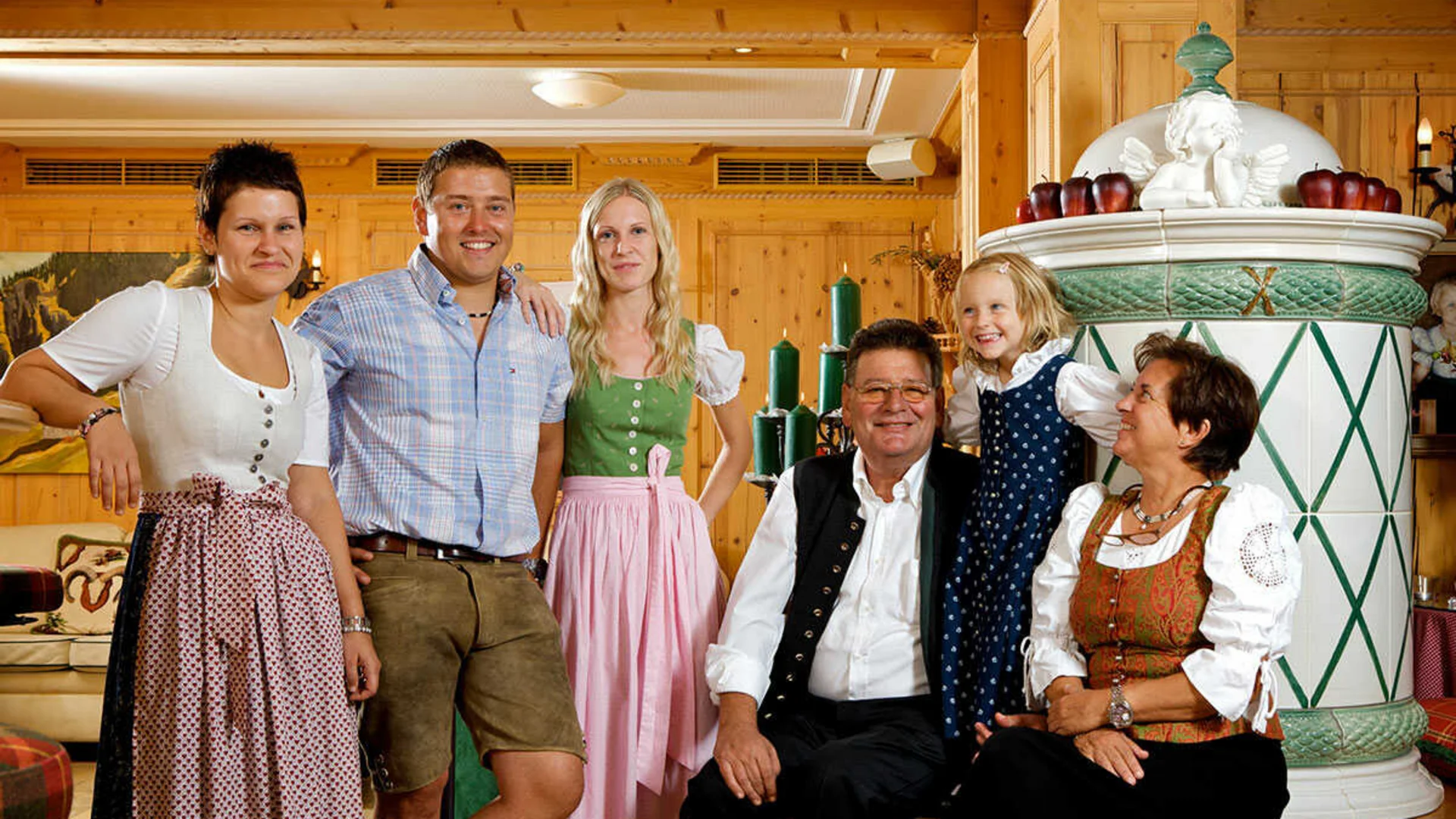 Das Hotel Familie in traditioneller bayerischer Tracht in einem gemütlichen Holzraum