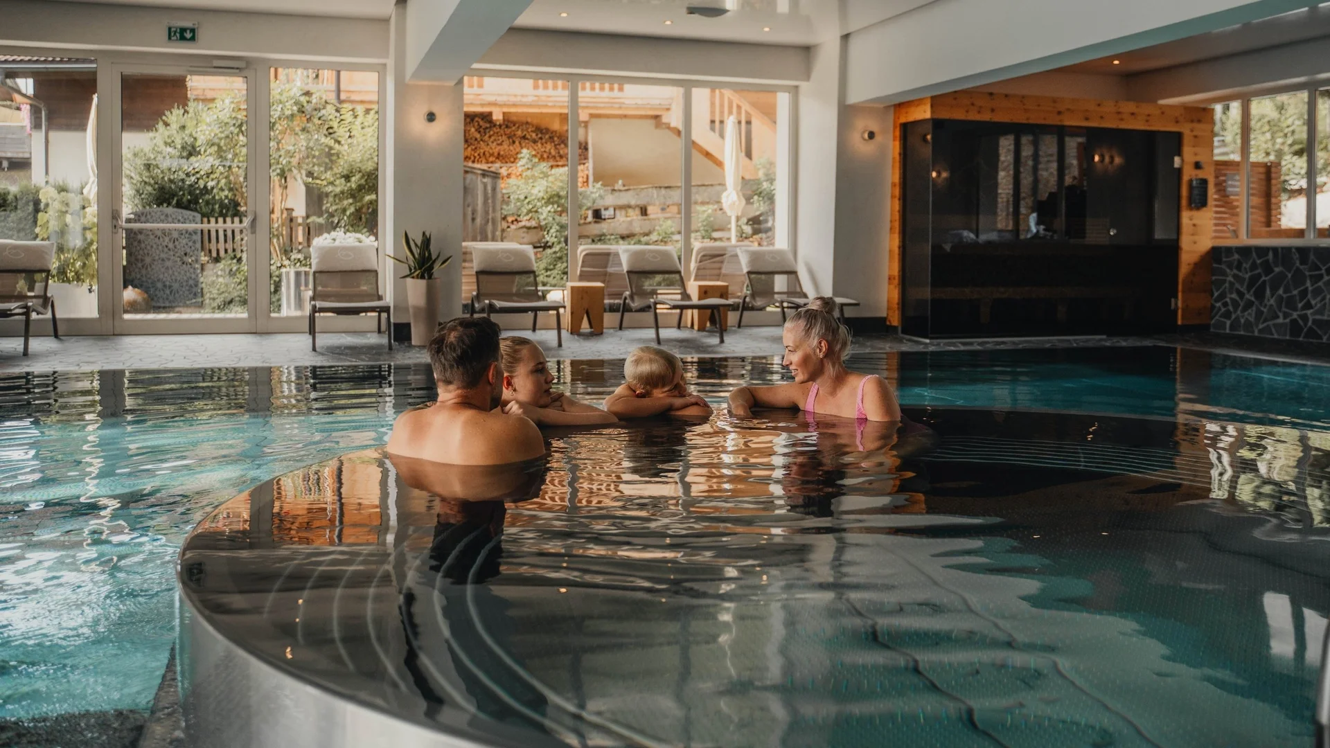 Saunawelt Vier Personen entspannen in einem beheizten Innenpool in einem Spa