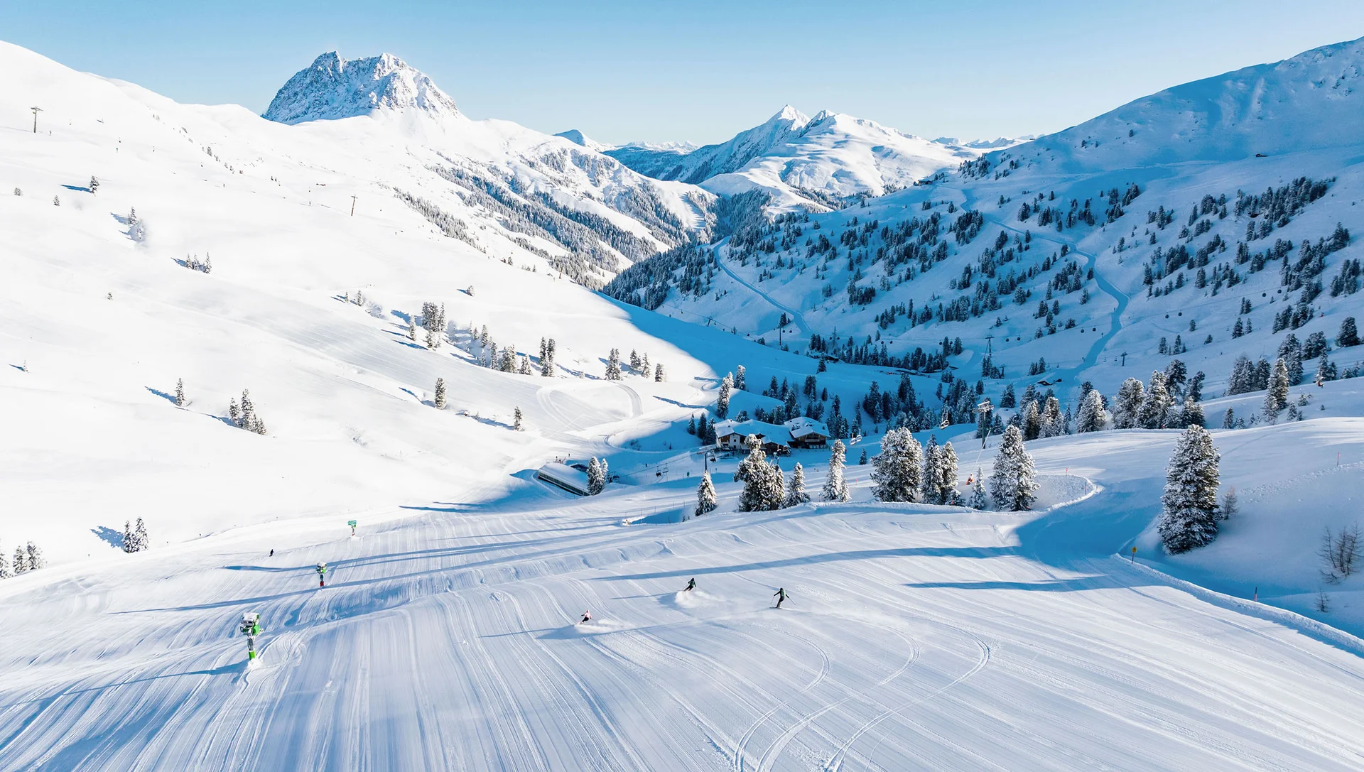 Skifahren Skifahrer auf verschneiter Piste in den Alpen bei klarem Himmel