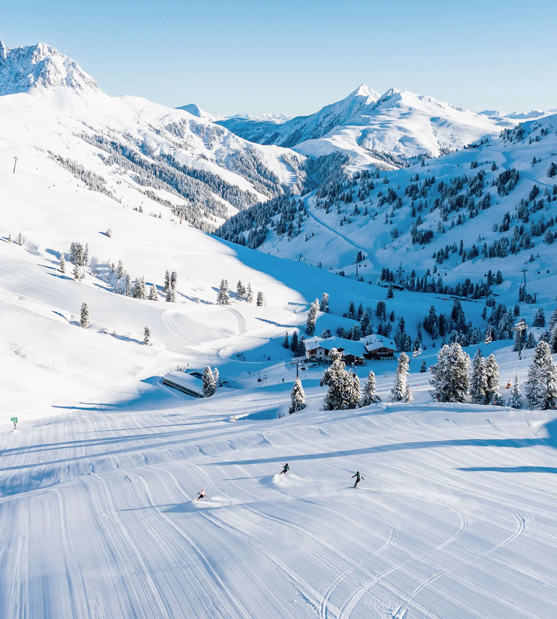Bergwinter Skifahrer auf verschneiter Piste in den Alpen bei klarem Himmel