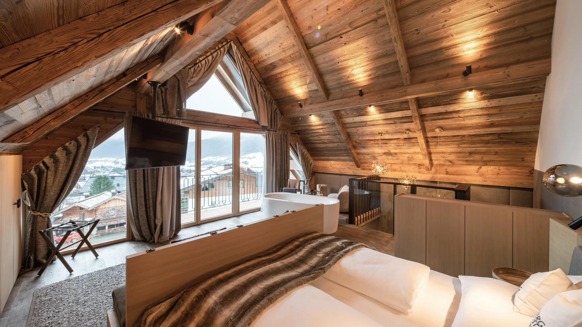 Baumhaus Gemütliches Schlafzimmer mit Holzwänden und Bergblick durch große Fenster