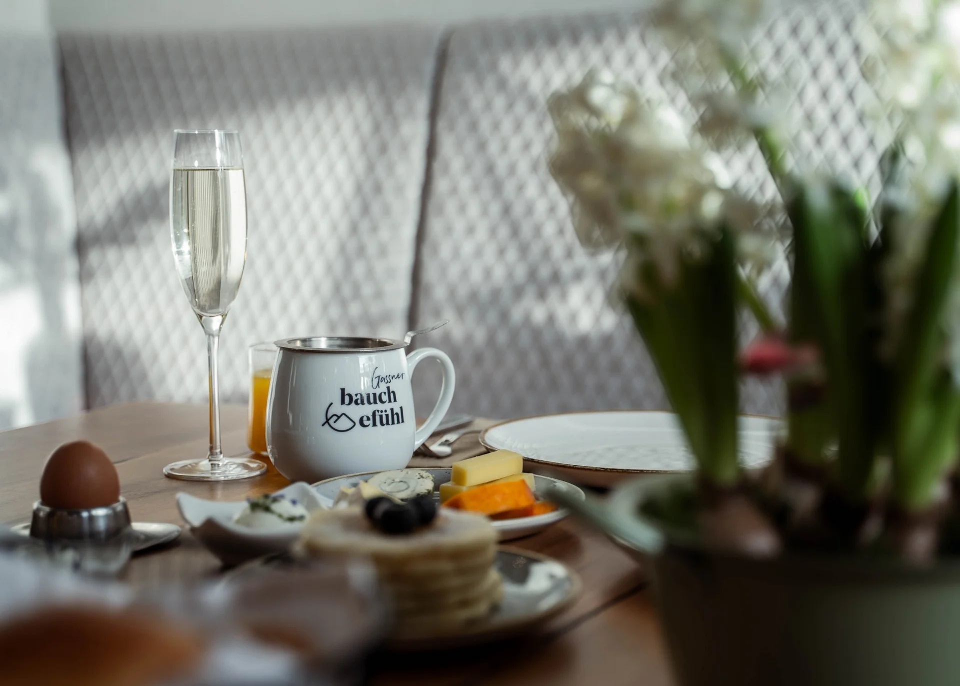 Das Hotel Frühstückstisch mit Ei, Käse, Getränken und Pflanzen im Vordergrund