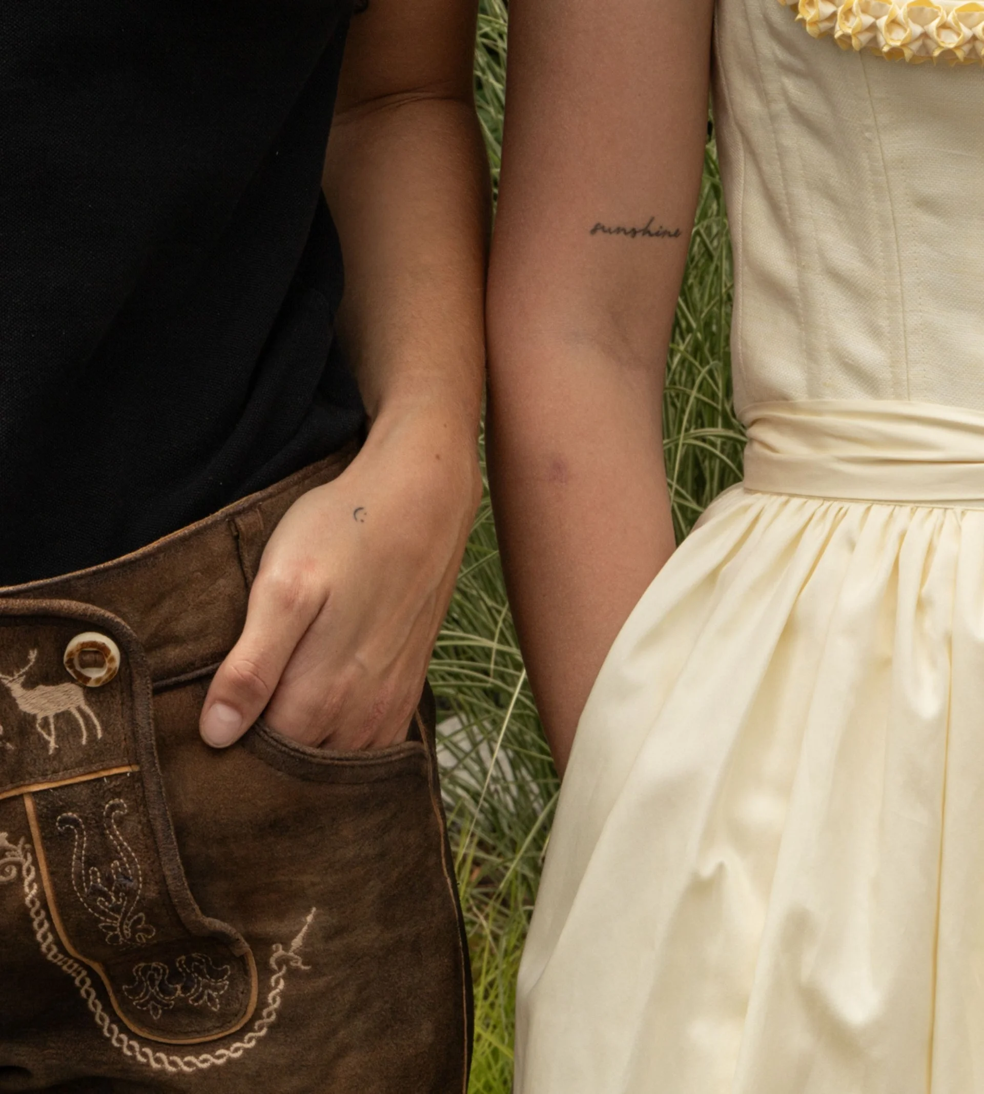 Jobs Hände von einem Trachtenpärchen in Lederhose und hellgelbem Dirndl