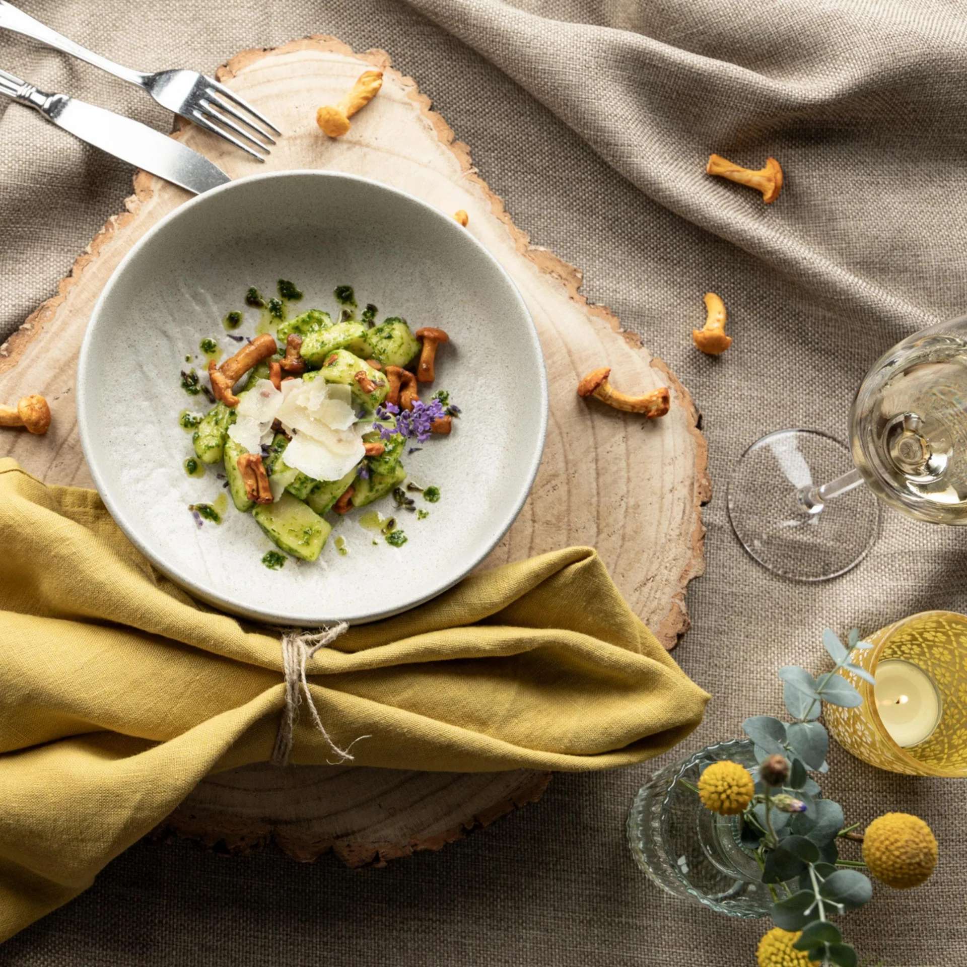 Kulinarik Schüssel mit Gnocchi, Pfifferlingen, Parmesan und grünem Pesto auf Holztisch