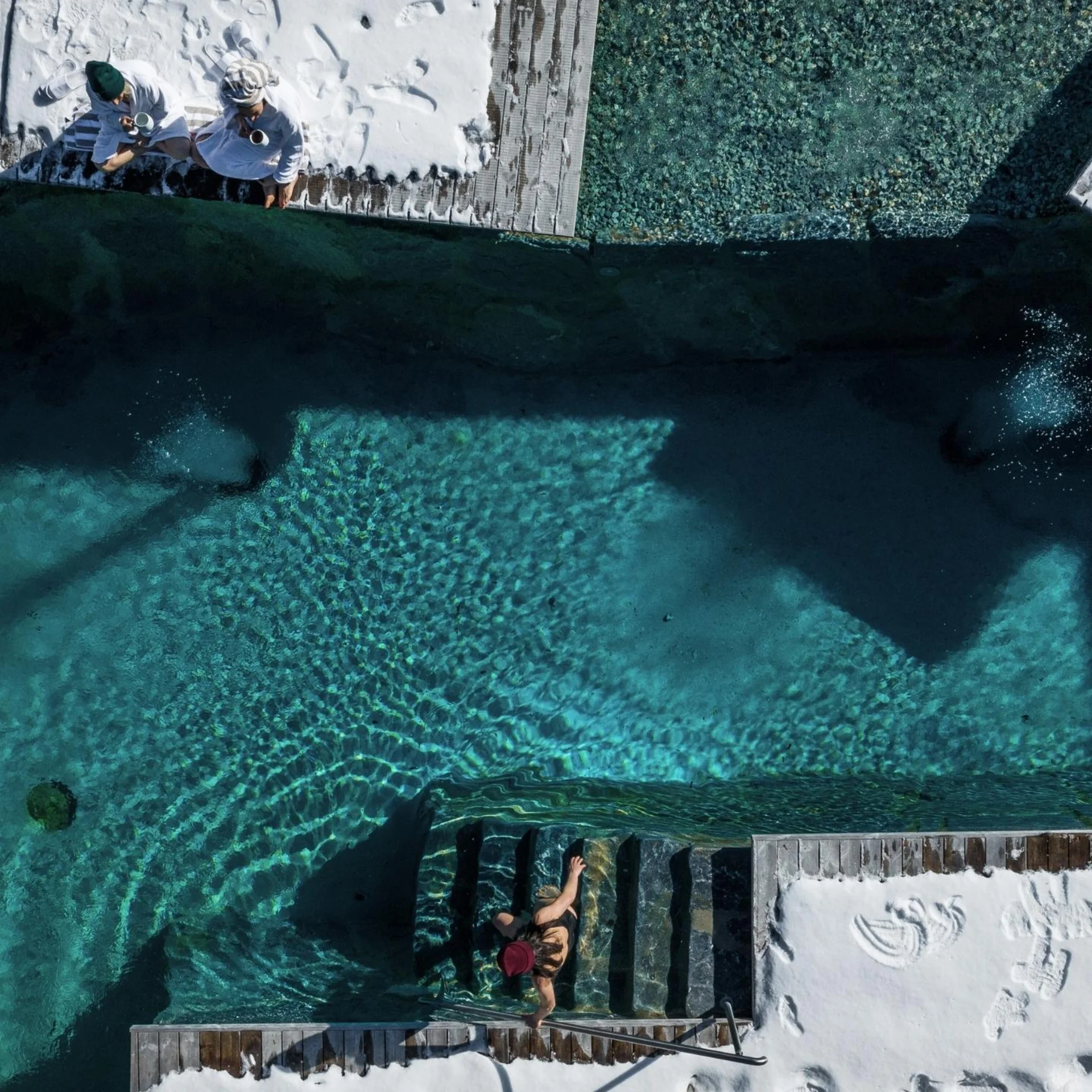 Wasserwelt Menschen entspannen auf Liegen neben klarem Pool mit Treppe und Schatten