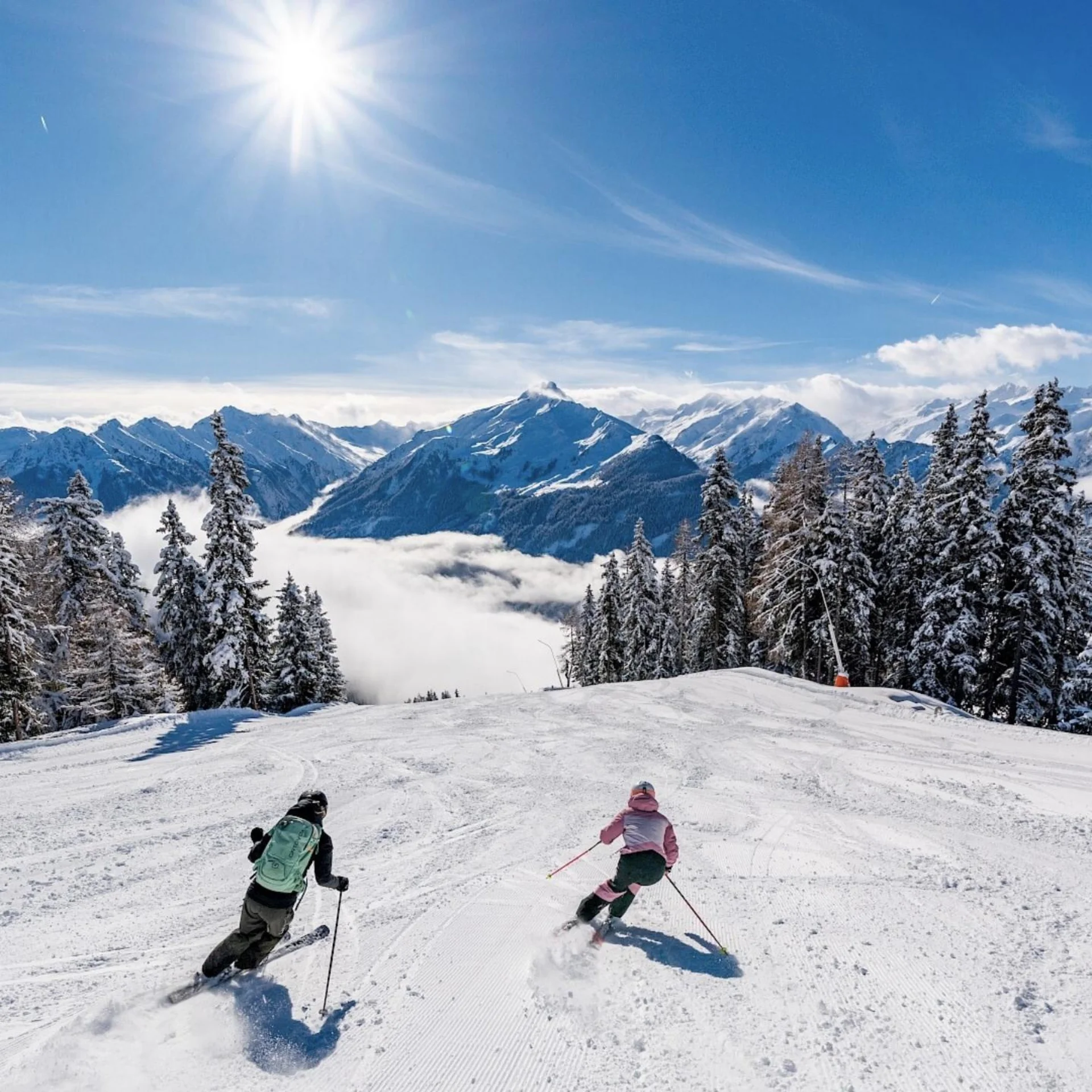 Bergwinter Zwei Skifahrer fahren bei sonnigem Wetter in schneebedeckten Bergen