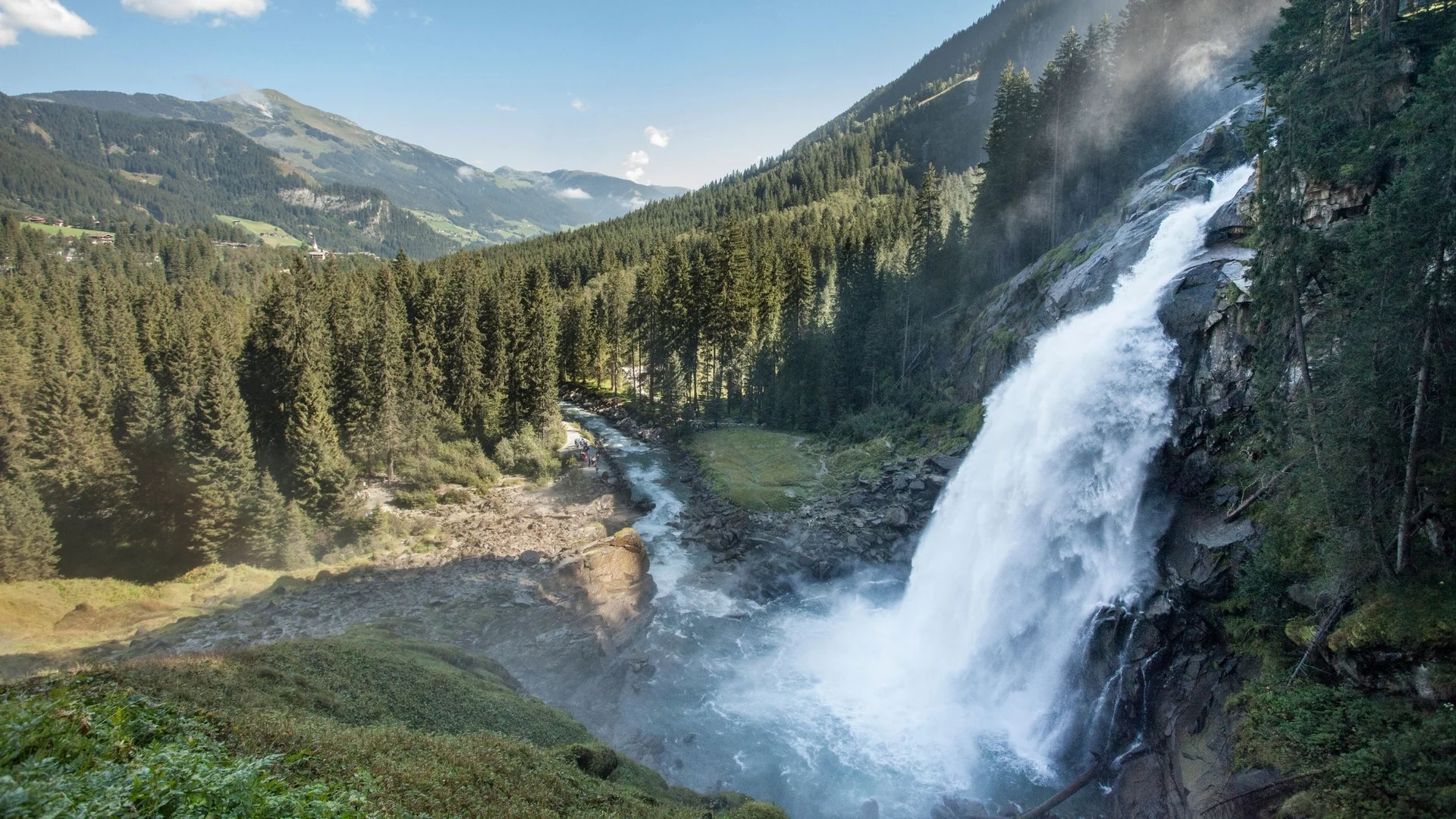 Wanderservice Wasserfall in bewaldeten Bergen mit Fluss und klarem Himmel
