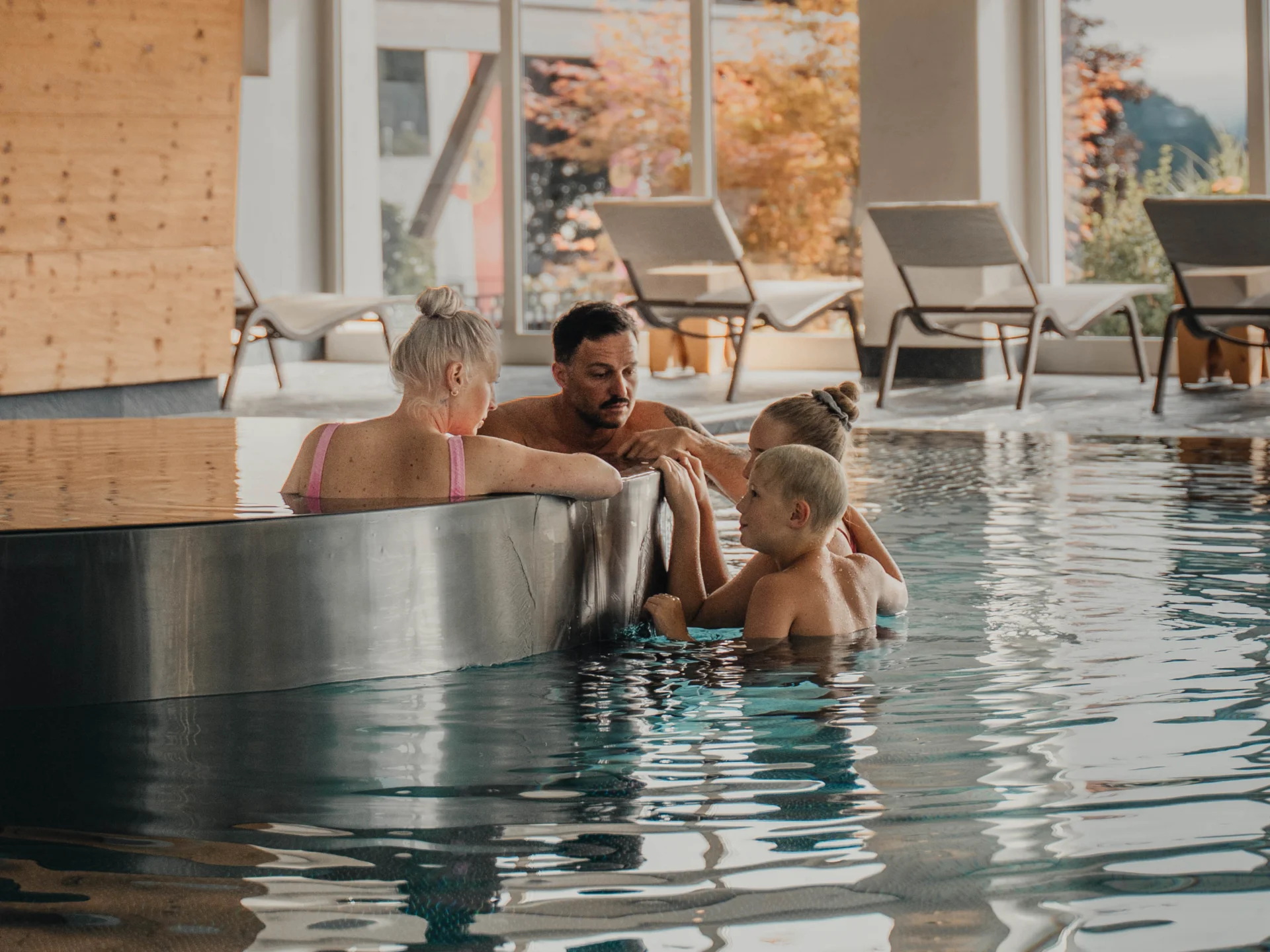 Massagen Familie entspannt im Hallenbad am Rande eines Whirlpool-Bereichs