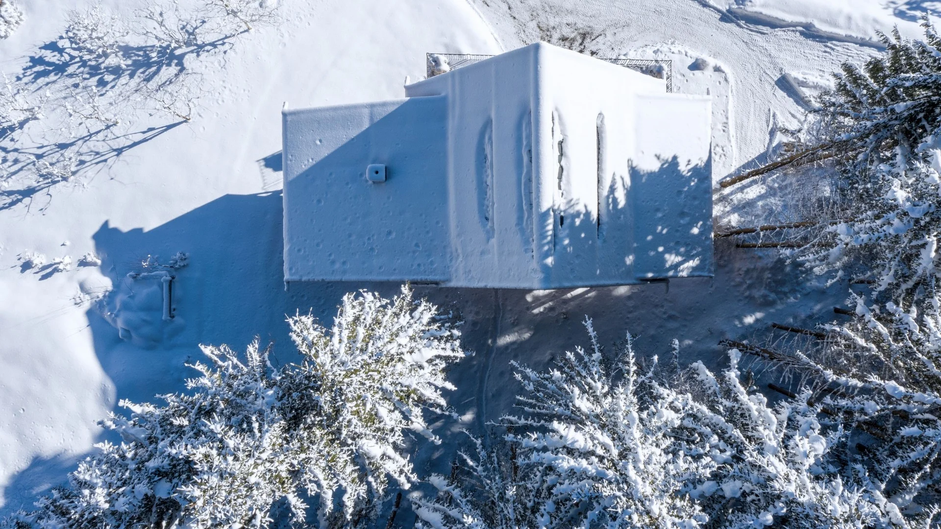 Baumhaus Vogelperspektive eines schneebedeckten Hauses und verschneite Bäume im Winter