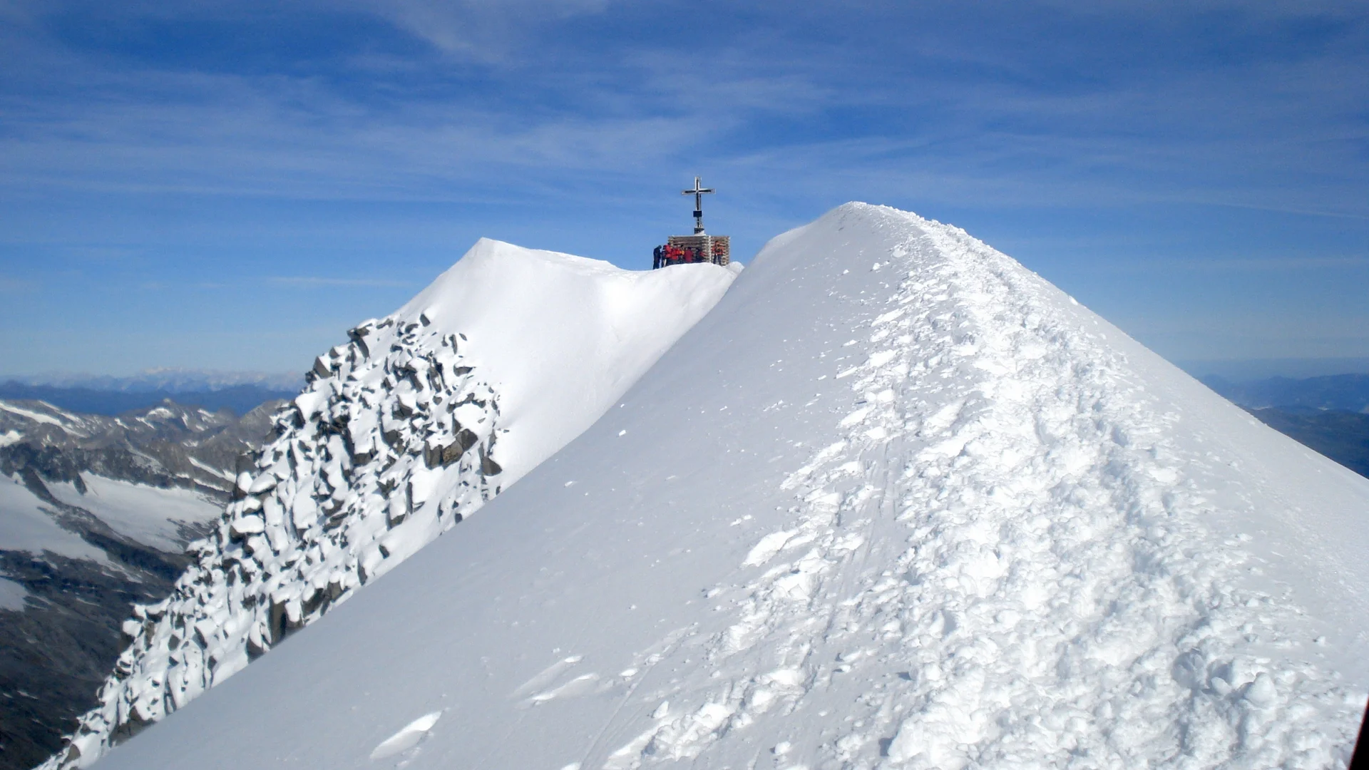 Großvenediger Schneebedeckter Berggipfel mit Kreuz unter blauem Himmel