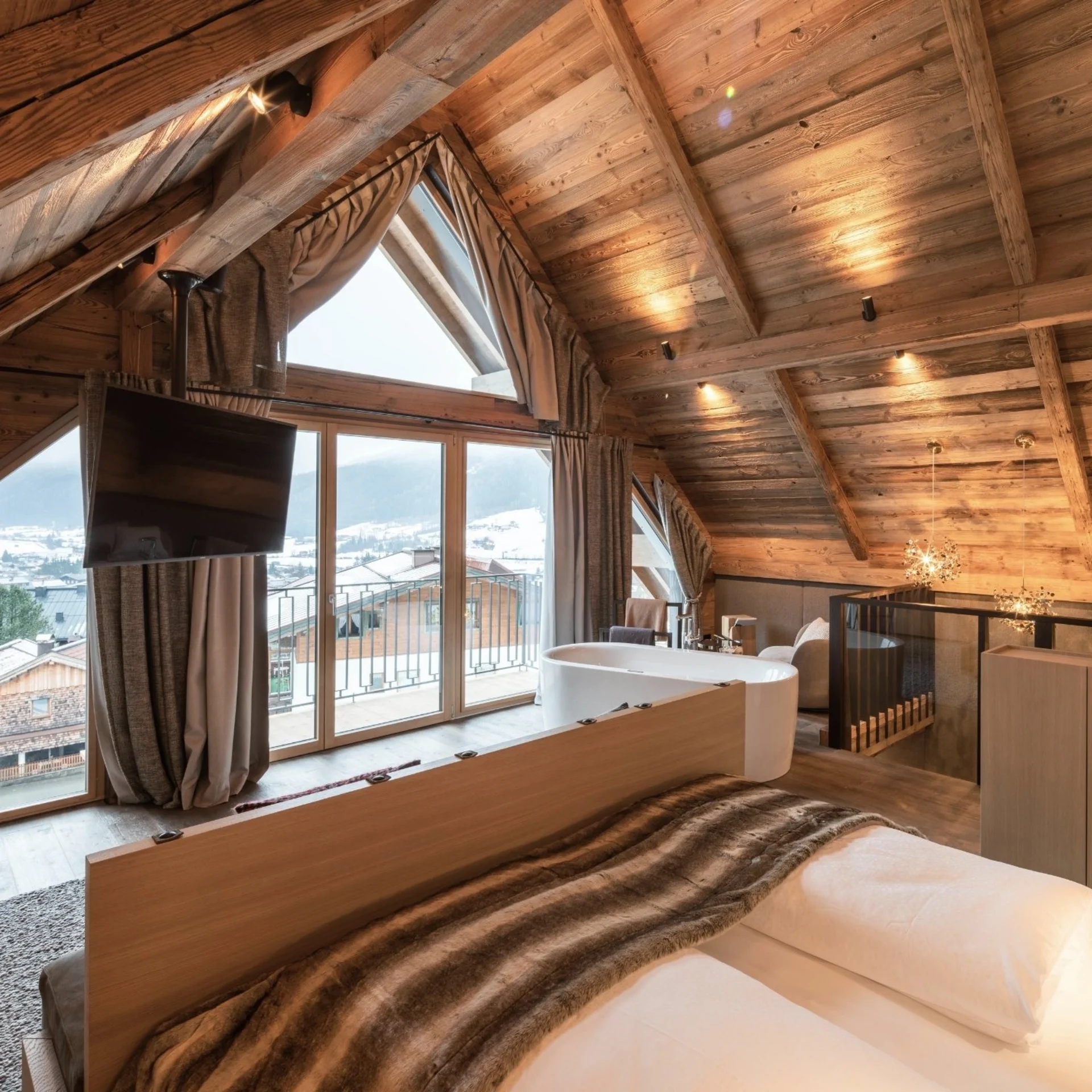 Baumhaus Gemütliches Schlafzimmer mit Holzwänden und Bergblick durch große Fenster