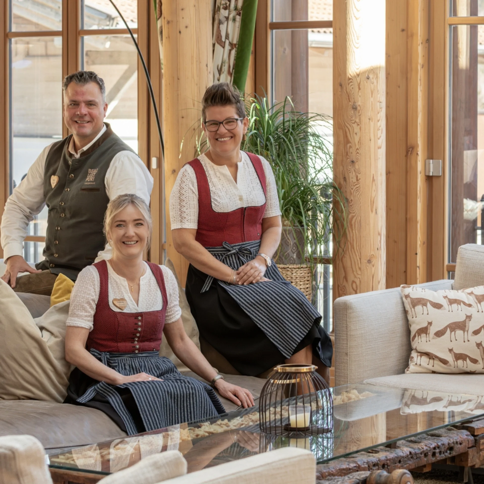 Baumhaus Vier Personen in traditioneller Tracht in einem Holzzaum eingerichteten Raum