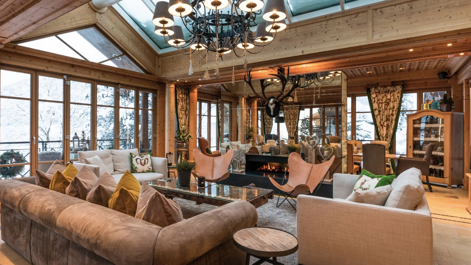Wohnen Gemütliches Wohnzimmer mit Ledersesseln, Kamin und Holzdecke in Berghütte