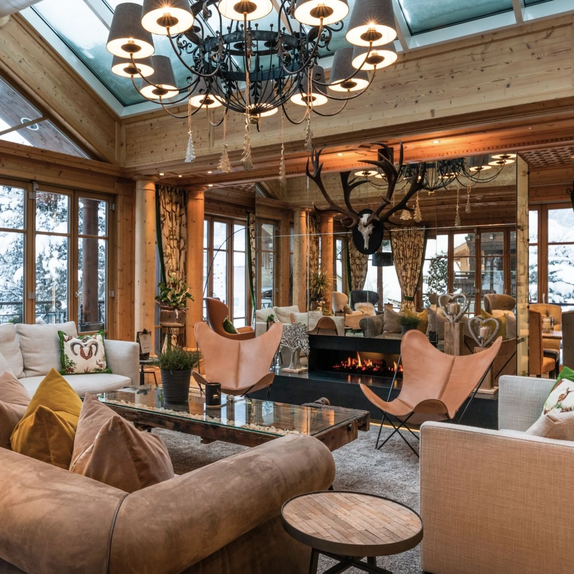 Kulinarik Gemütliches Wohnzimmer mit Ledersesseln, Kamin und Holzdecke in Berghütte
