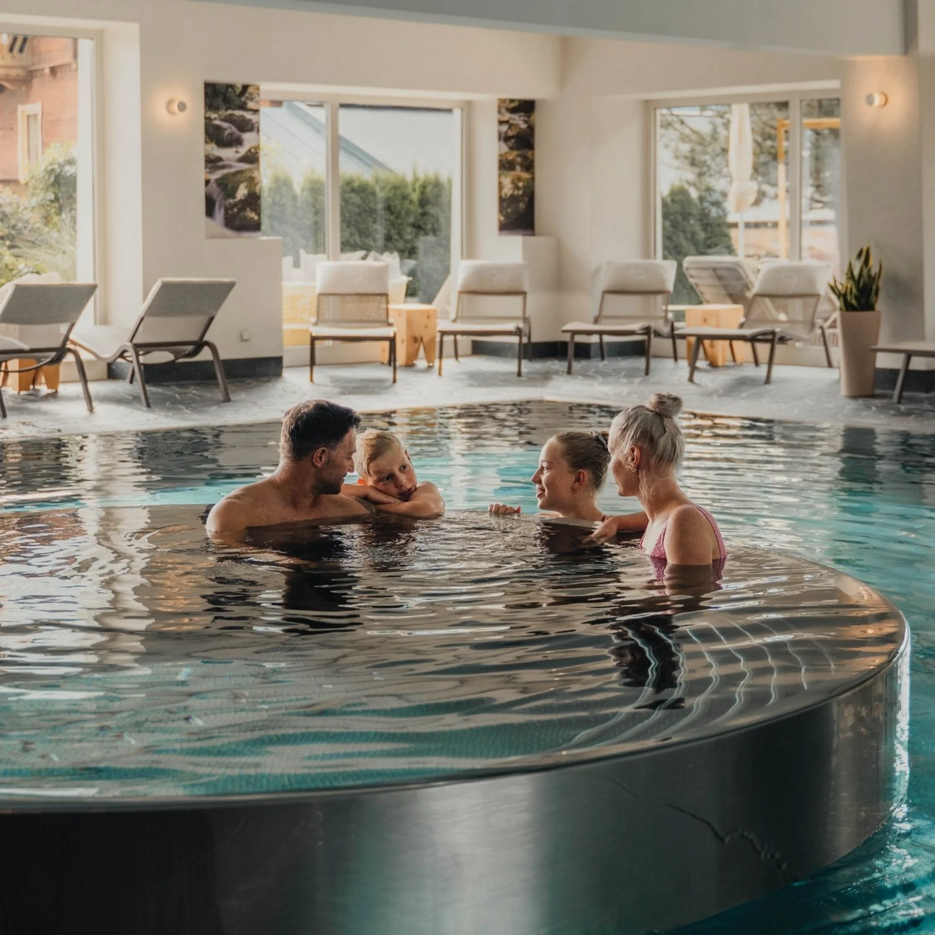 Bergsommer Familie entspannt in rundem Whirlpool im Hallenbad