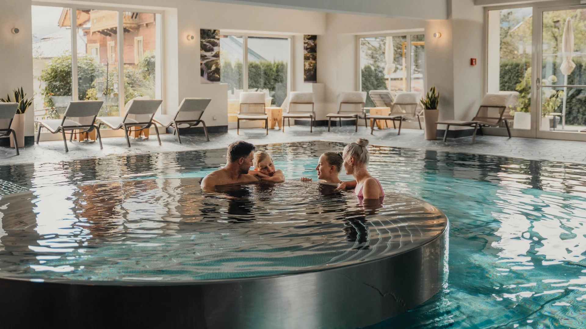Wasserwelt Familie entspannt in rundem Whirlpool im Hallenbad