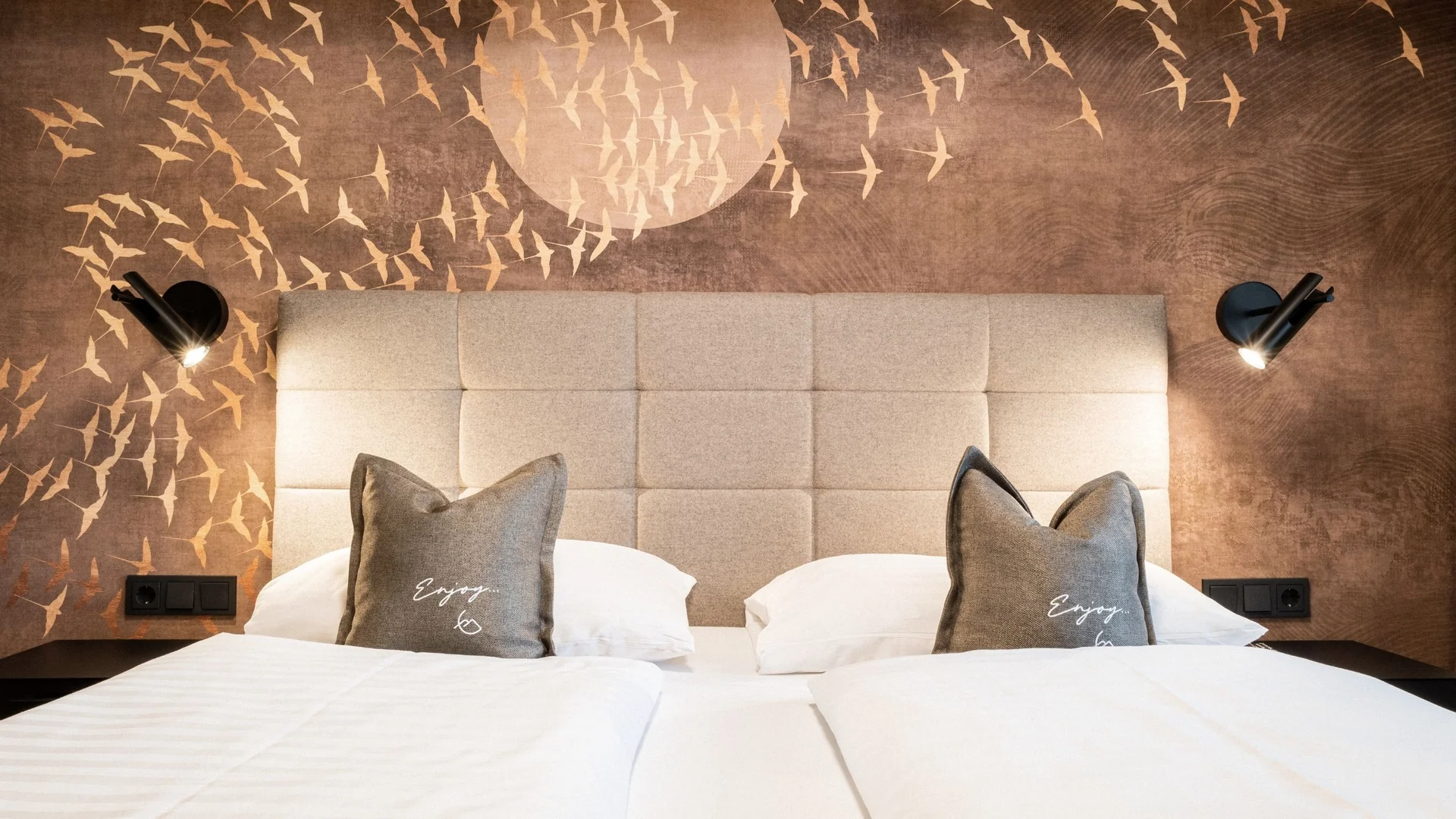 Inklusivleistungen Modernes Hotelzimmer mit Doppelbett und dekorativer Vogel-Vliestapete
