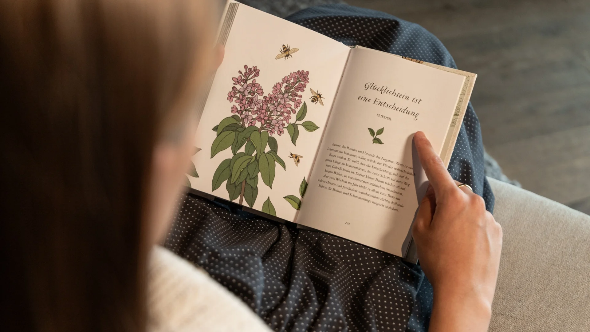 Baumhaus Person liest Buch mit floralem Bild und deutschem Text über Glücklichsein