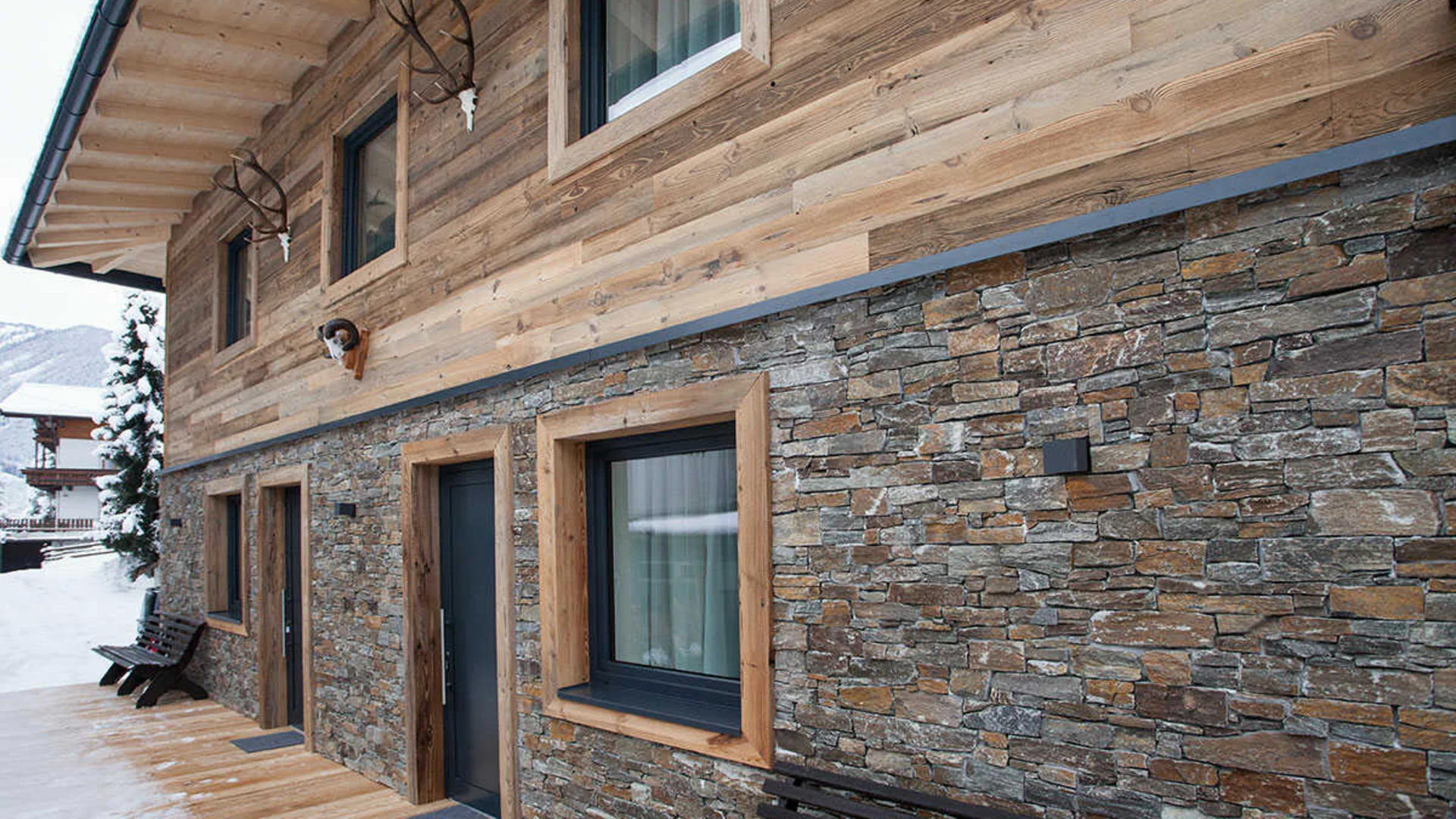 Das Hotel Außenwand eines Hauses mit Holz und Steinverkleidung im Schnee