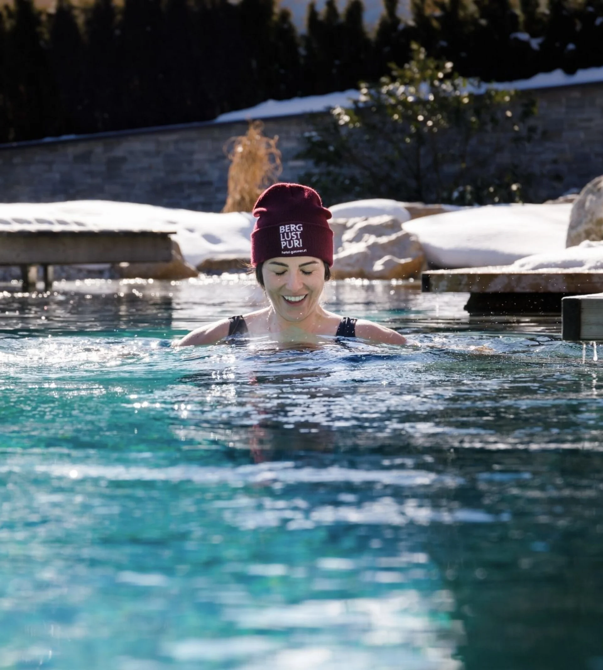 Wasserwelt Frau im Winter draußen im Pool mit Mütze und Schnee im Hintergrund