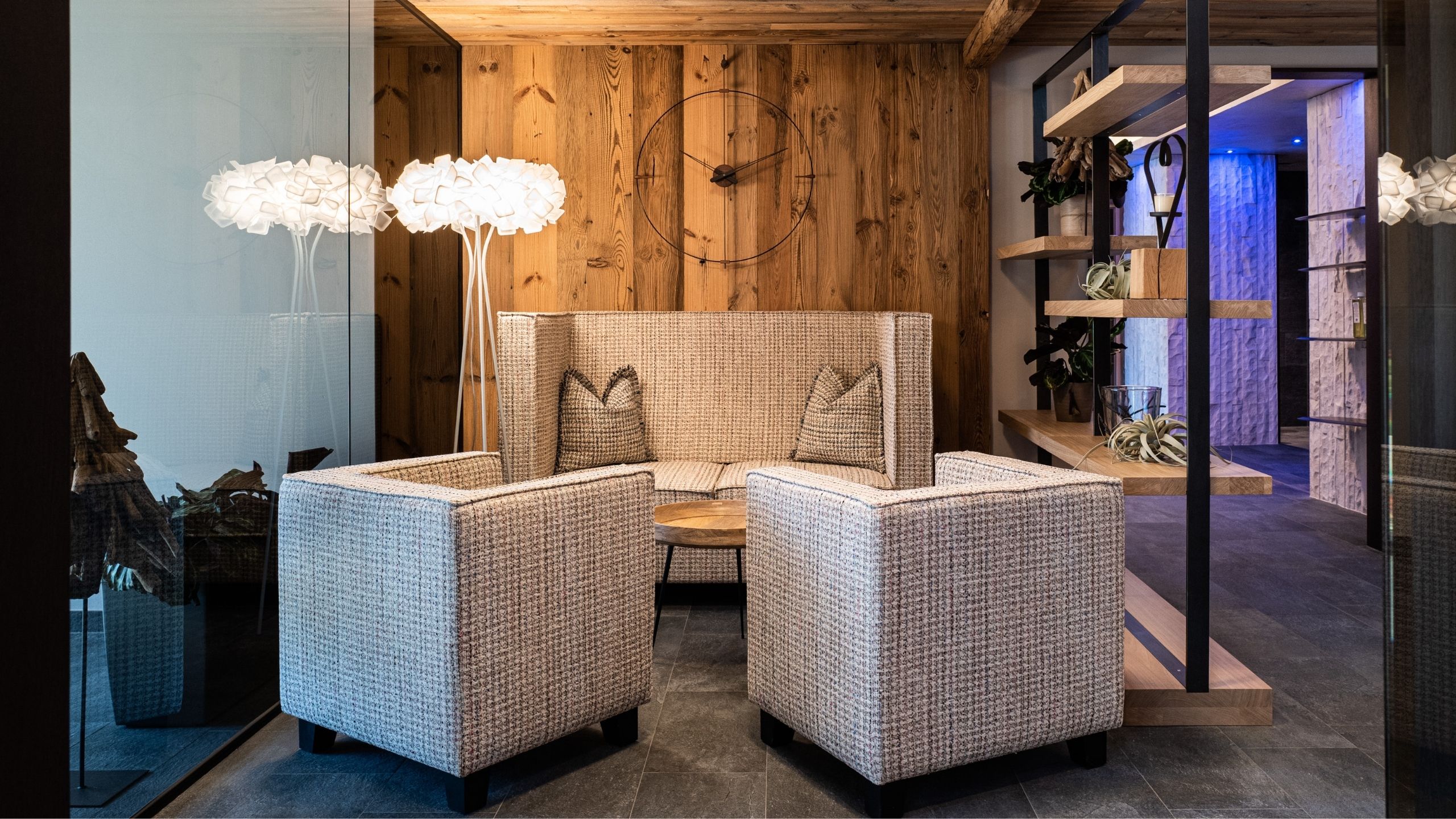 Saunawelt Gemütlicher Sitzbereich mit zwei Sesseln, Sofa, Holzwand und Stehlampe