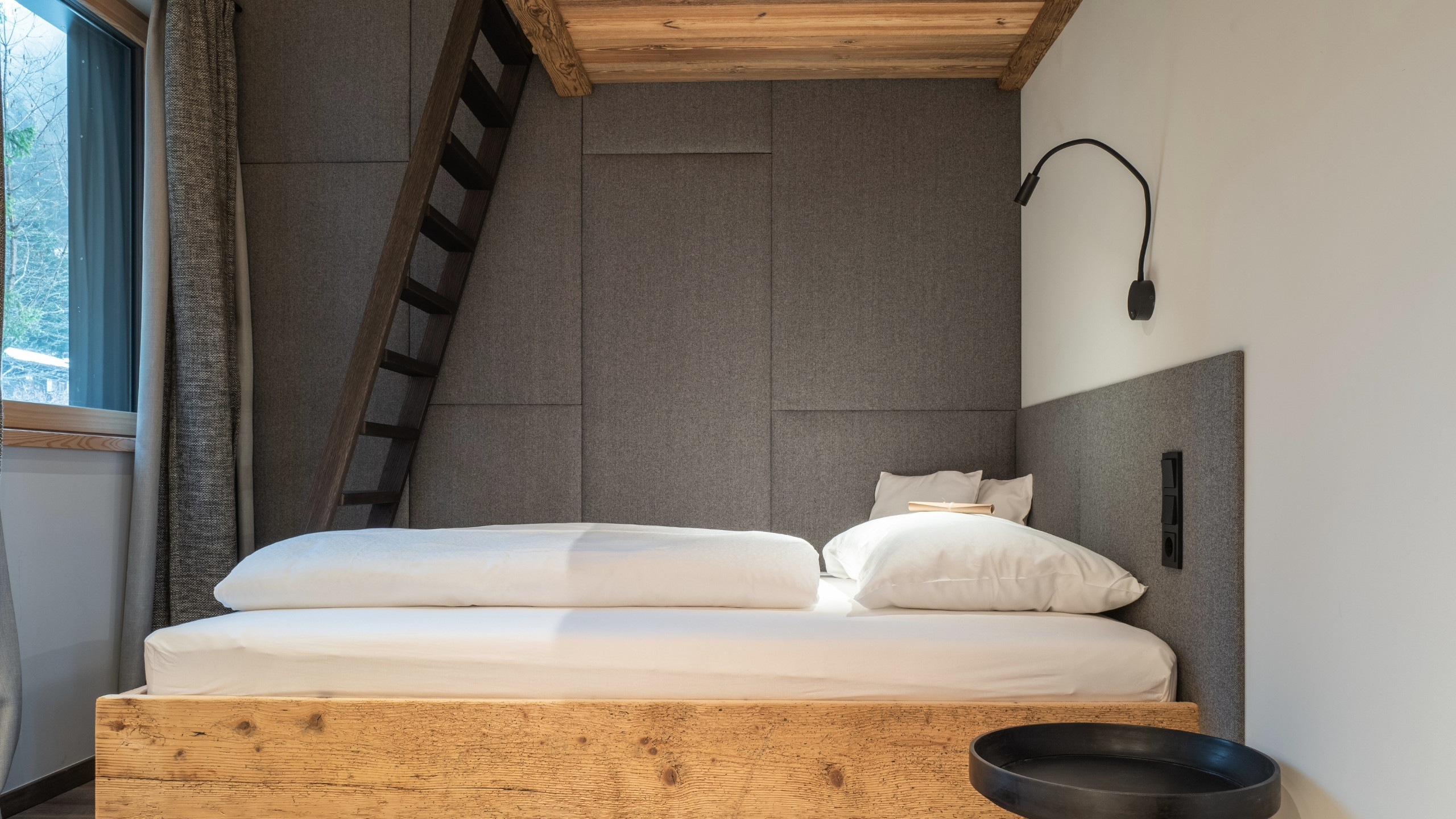 Baumhaus Kleines Schlafzimmer mit Holzrahmenbett, gepolsterter Wand und Leselampe