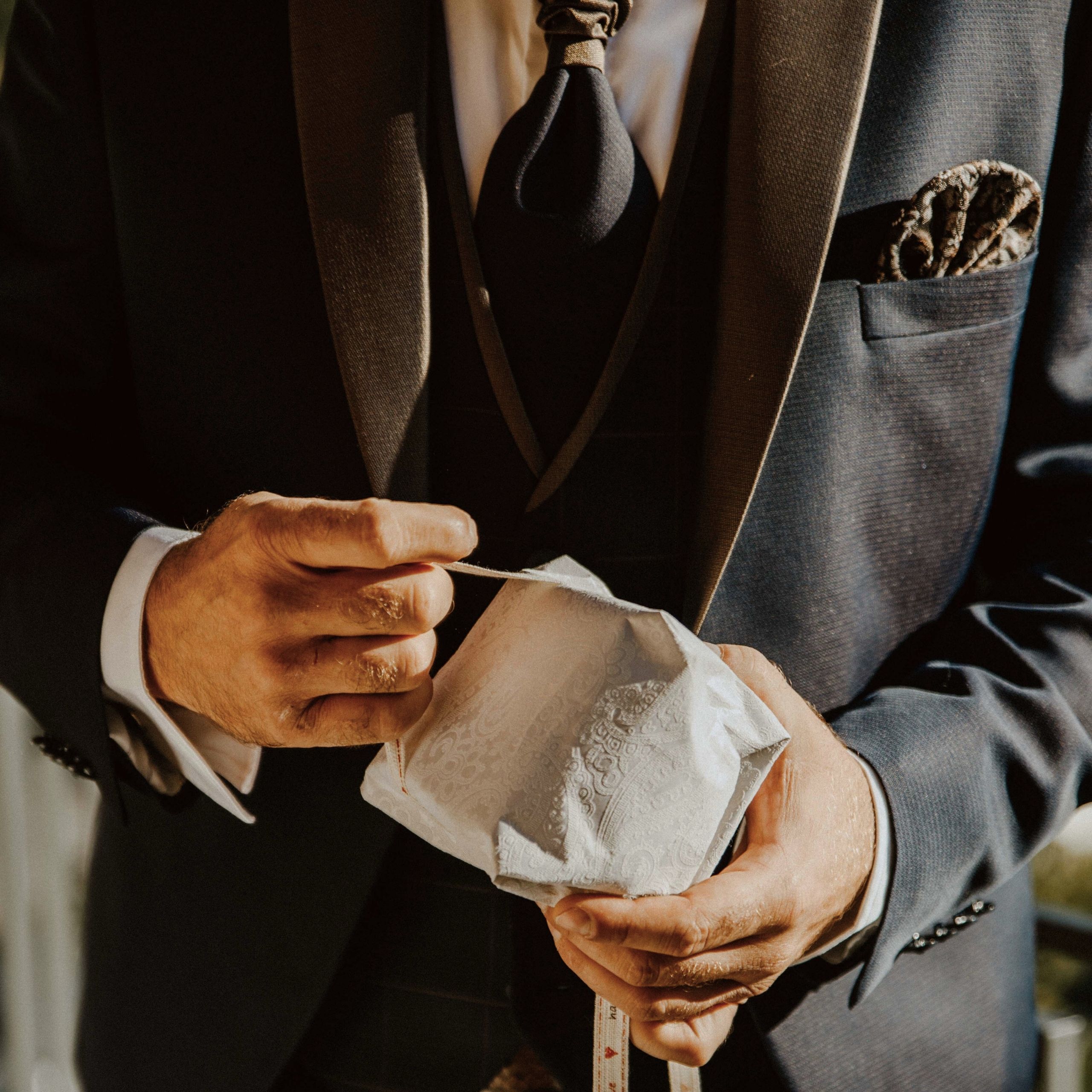 Baumhaus Mann im Anzug hält eine dekorative weiße Maske in den Händen