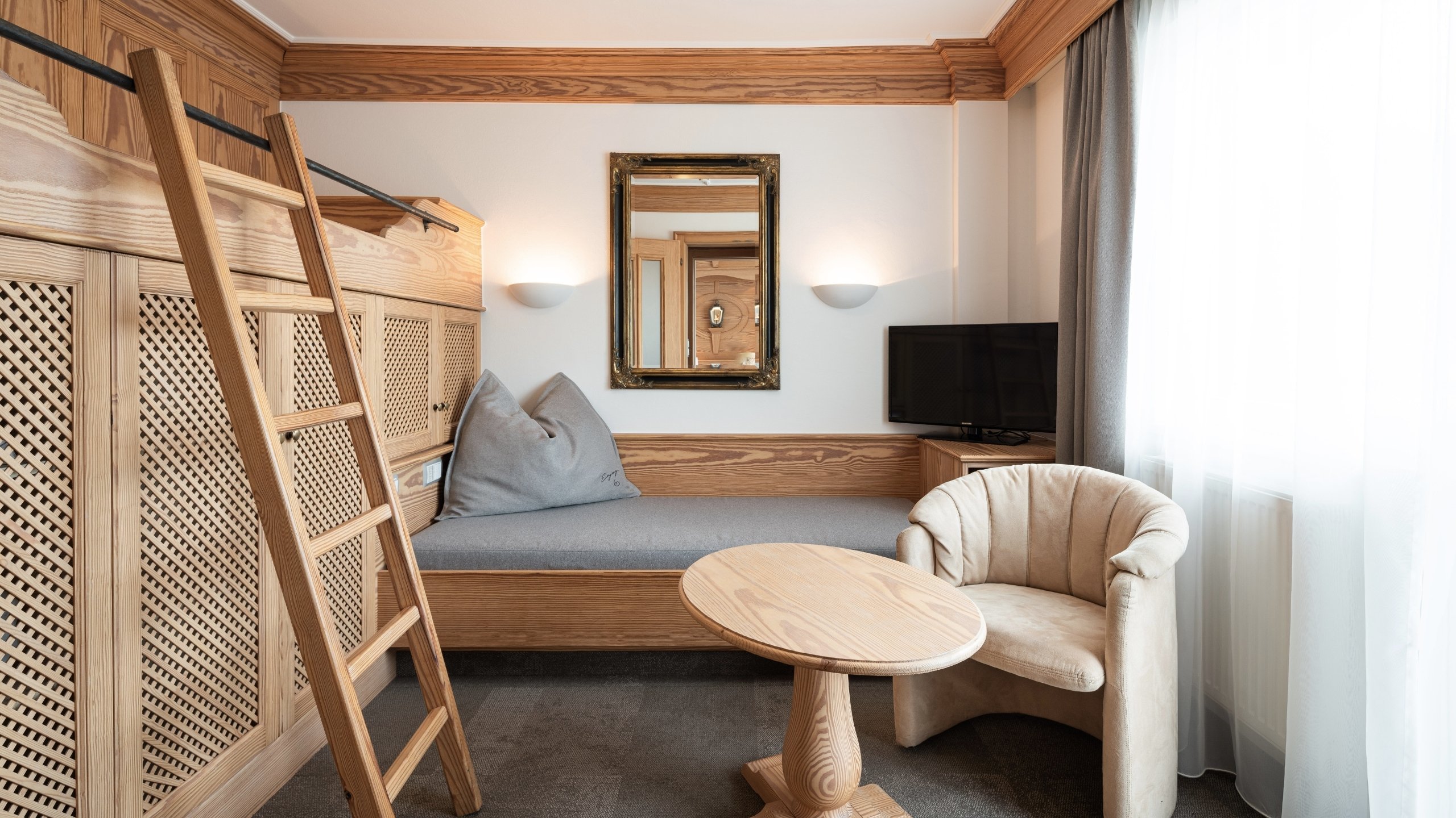 Wohnen Gemütliche Ecke mit Holzleiter, Sitzbank, Sessel und kleinem Tisch neben Fenster